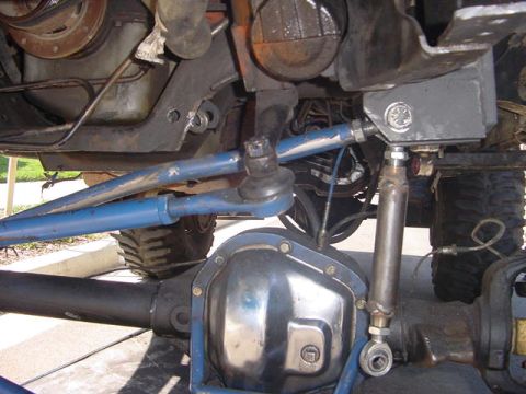 1991 Ford Bronco - Close-up of the vehicle's undercarriage shows the steering linkage and front differential assembly.