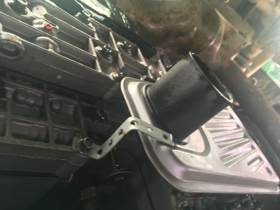 Underside of a vehicle showing a transmission pan and filter.