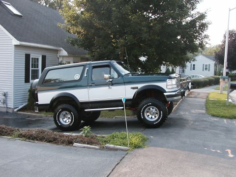 1994 Ford Bronco - This two-tone green and white Ford Bronco is shown from the side, BFGoodrich tires and a lifted suspension.