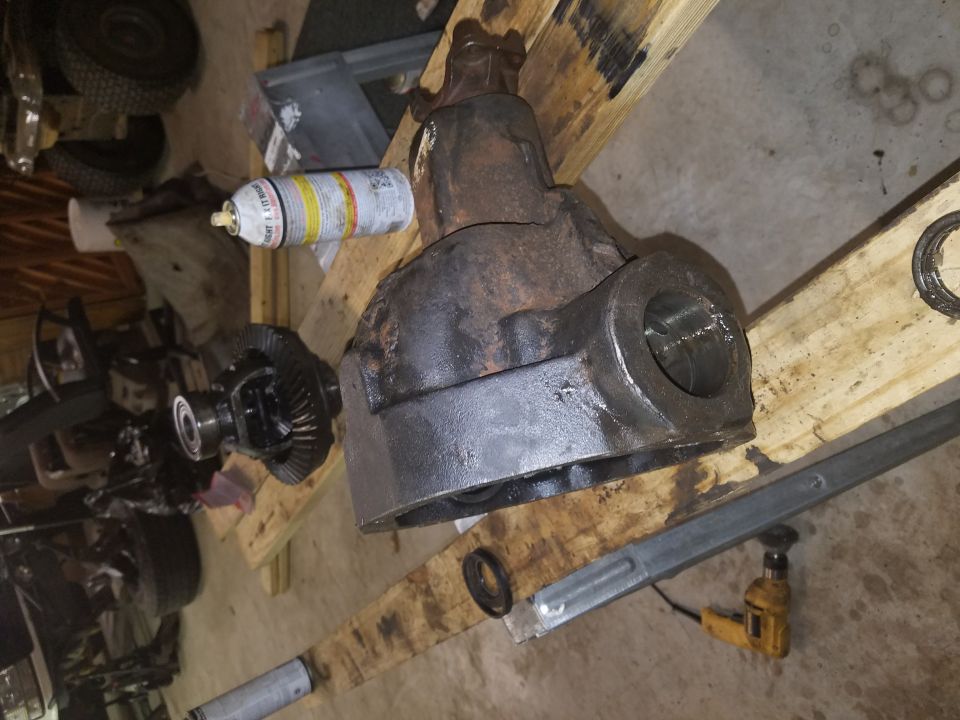 Differential housing and gears on wooden planks with a spray can.
