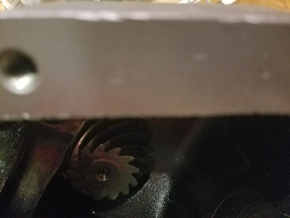 Metal car part with a bolt hole, possibly from a vehicle's interior