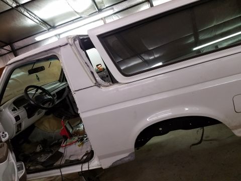 1996 Ford Bronco - The interior and driver's side of a white 1996 Ford Bronco is shown, with the doors removed and the interior partially disassembled. The ve…