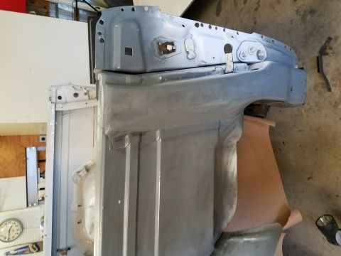 1996 Ford Bronco - A partially restored vehicle chassis, likely a Ford Bronco, is shown in a garage setting. The metal components are covered in primer and ap…