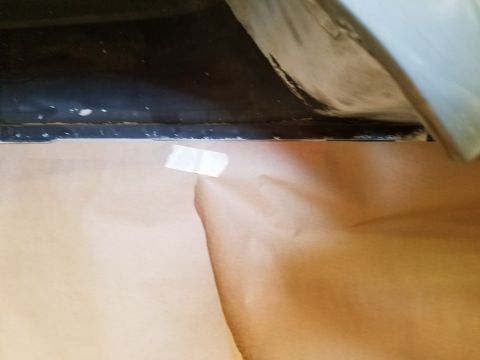 1996 Ford Bronco - A piece of masking tape is affixed to a section of brown paper that is covering the lower body of a vehicle. The upper portion of the image…