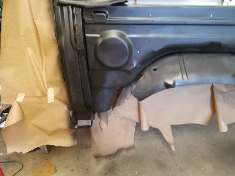 1996 Ford Bronco - Vehicle body panel covered in masking paper, likely for painting or repair.