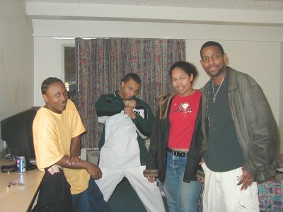 1997 Ford Taurus - Four individuals pose for a photo in what appears to be a hotel room, with a Supermotors logo in the corner.