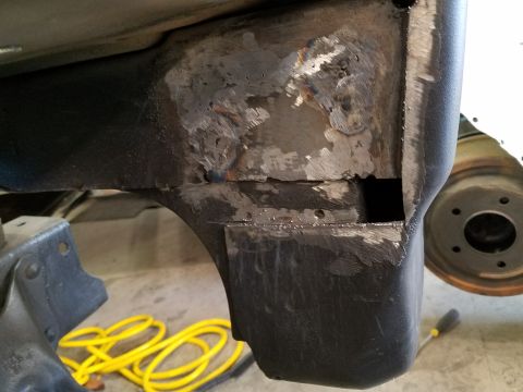 1996 Ford Bronco - Detail of a vehicle's undercarriage showing repairs to the frame and a portion of the wheel.