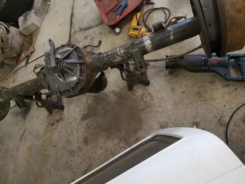 1996 Ford Bronco - A disassembled rear axle assembly is shown on a workshop floor with tools.