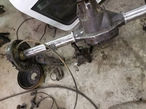 1996 Ford Bronco - A disassembled rear axle assembly is shown with tools and parts scattered around it.