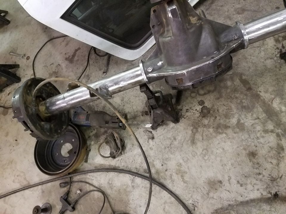 Rear axle assembly with brake drum and cutting tool on a concrete floor