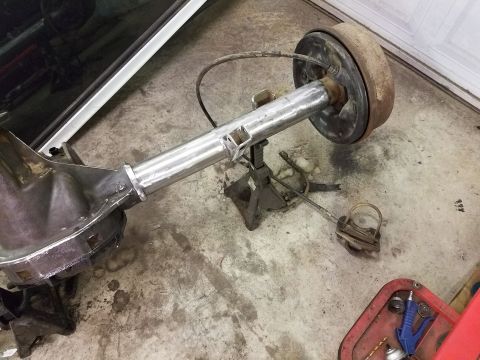 1996 Ford Bronco - A disassembled rear axle assembly rests on jack stands, with brake components visible.