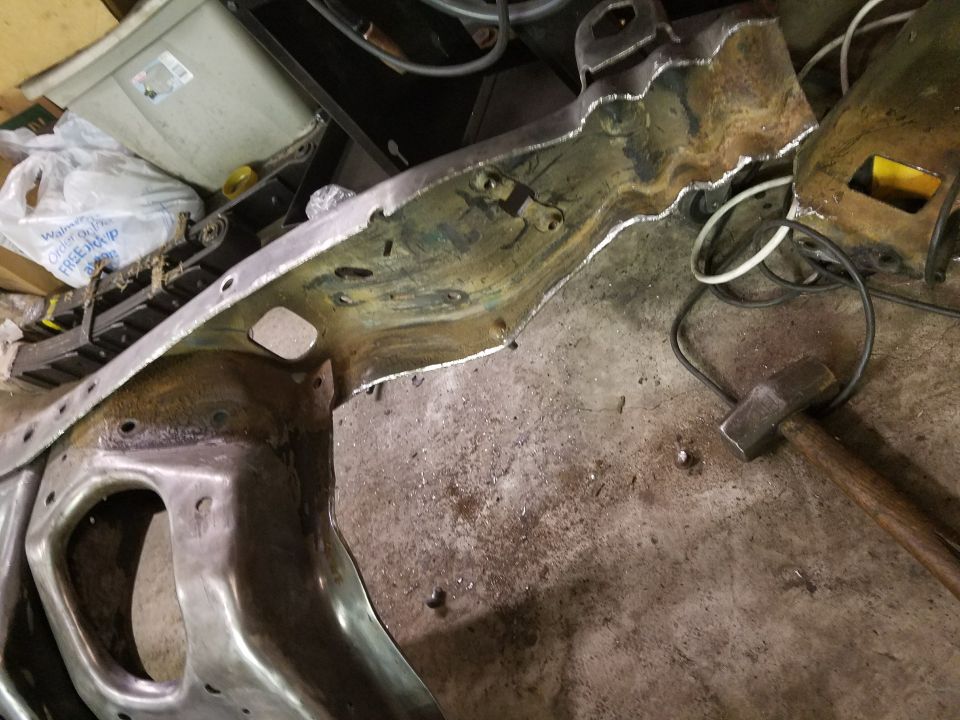 Metal frame section with hammer and electrical cord on concrete floor