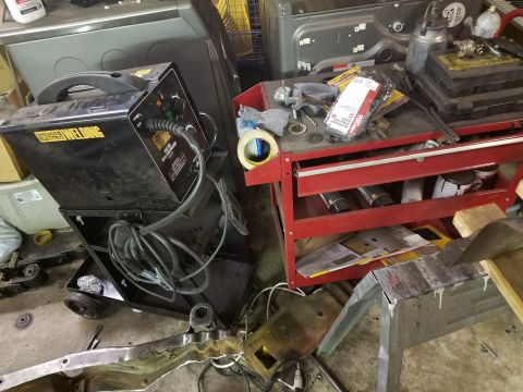 1996 Ford Bronco - A welding machine and a red tool chest filled with supplies are in a cluttered workshop setting.
