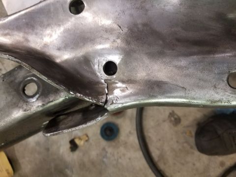 1996 Ford Bronco - A close-up view of a damaged metal suspension part, showing a significant crack.