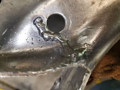 1996 Ford Bronco - Close-up of a metal component showing recent welding work and a circular opening.