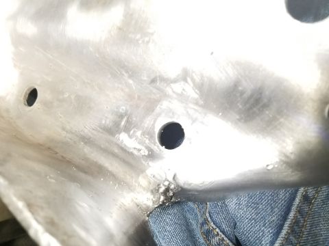1996 Ford Bronco - A close-up view of a metal component, showing drilled holes and evidence of repair work.