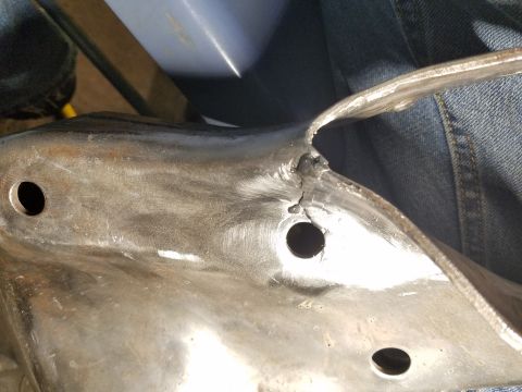 1996 Ford Bronco - Damaged metal part with visible cracks and mounting holes.