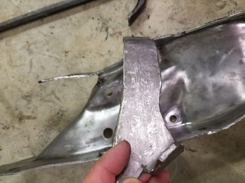 1996 Ford Bronco - A damaged metal bracket is examined, showing signs of repair and deformation.
