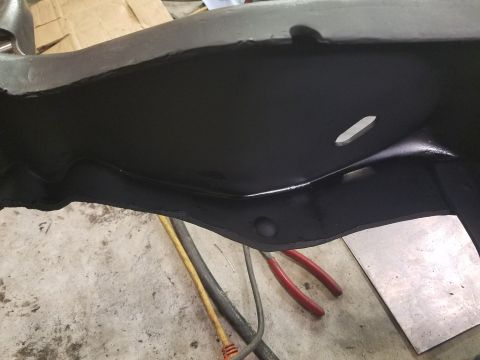 1996 Ford Bronco - Close-up view of a black painted frame section, possibly from a vehicle, with tools visible in the background.