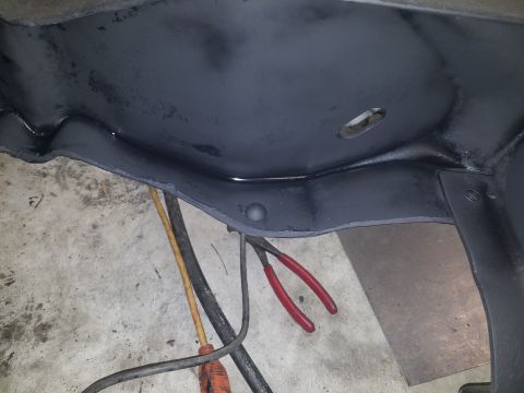 1996 Ford Bronco - Vehicle frame section with tools and electrical cords visible on the concrete floor.