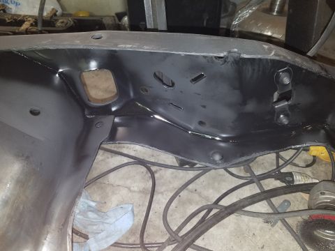 1996 Ford Bronco - A section of a vehicle's frame, likely undergoing restoration or repair, is shown with tools on the floor.