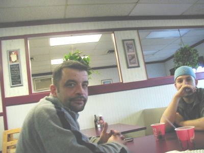 1997 Ford Taurus - Two men are seated at a table inside a restaurant, with a visible logo for SuperMotors.net.