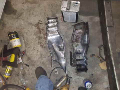 1996 Ford Bronco - Metal car parts are laid out on a concrete floor next to various tools and containers.