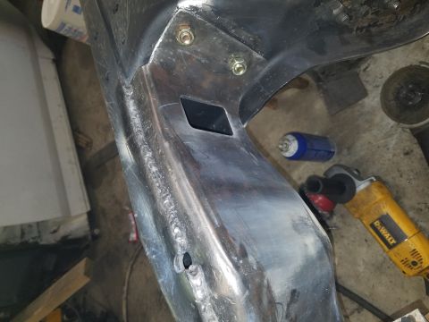 1996 Ford Bronco - Close-up view of a metal frame section undergoing repair, showing welds and a distinctive diamond-shaped opening.