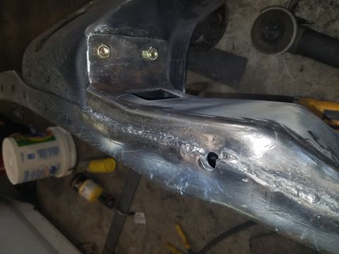 1996 Ford Bronco - Welded metal frame part with visible bolts and a small hole.