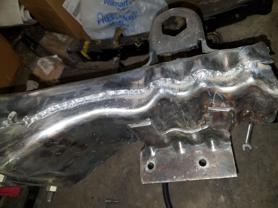 Welded metal frame component with bolt holes and a hexagonal bracket