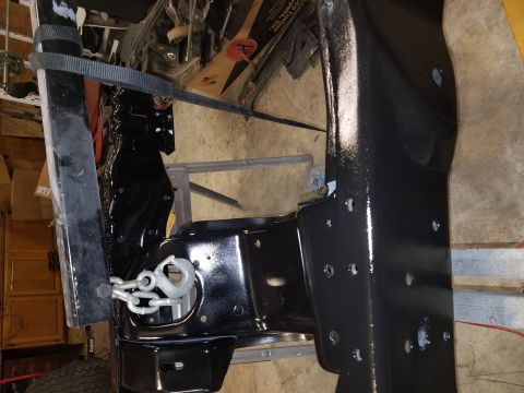 1996 Ford Bronco - Close-up view of a vehicle frame section, painted black, a tow hook and chain assembly.