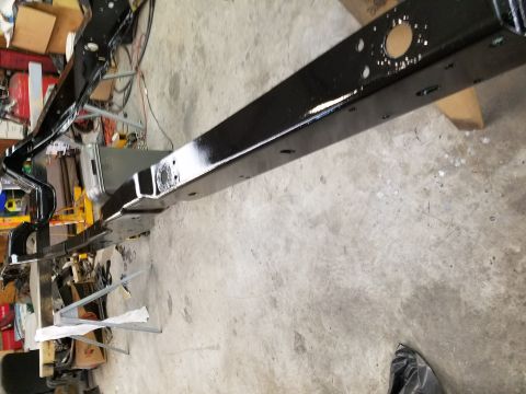 1996 Ford Bronco - A freshly painted vehicle frame sits on a workshop floor, ready for reassembly.