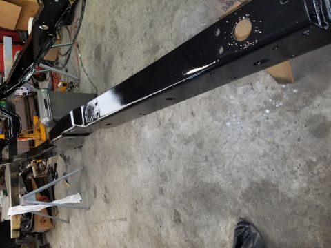 1996 Ford Bronco - A vehicle frame, likely undergoing restoration, is shown from a side angle on a concrete floor.