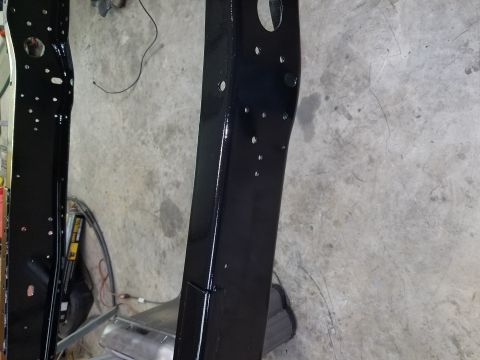 1996 Ford Bronco - The photo shows two black painted vehicle frame rails, likely undergoing restoration or repair.