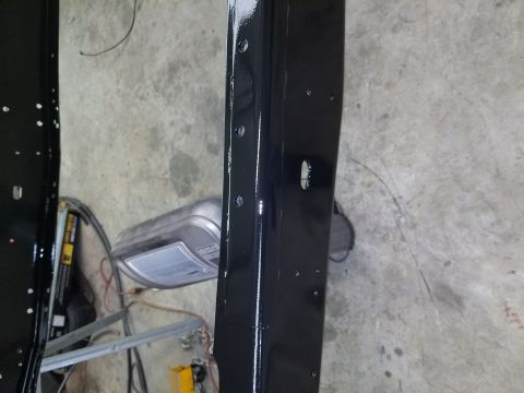 1996 Ford Bronco - A close-up view of a black metal frame, possibly part of a vehicle chassis, against a concrete floor.