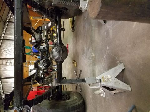 1996 Ford Bronco - Undercarriage of a vehicle undergoing maintenance, showing frame and suspension parts.