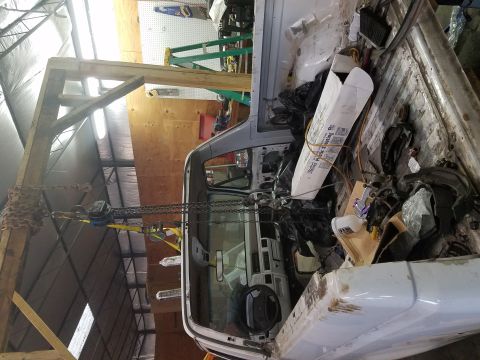 1996 Ford Bronco - The interior of a white truck cab is visible, with a hoist and chains suspended above it.
