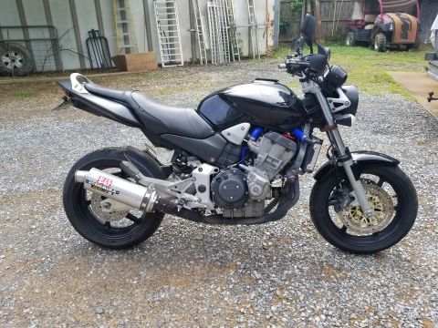 2005 Honda CB9000 - Side view of a black motorcycle a Yoshimura exhaust system and aftermarket blue hoses.