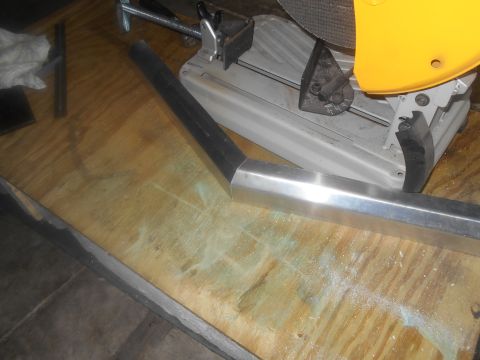 1992 Ford Bronco - Metal tubing is being cut by a yellow and gray chop saw on a wooden workbench.