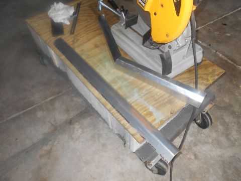 1992 Ford Bronco - Metal bars and a chop saw are on a workbench, with a Supermotors.net logo in the corner.