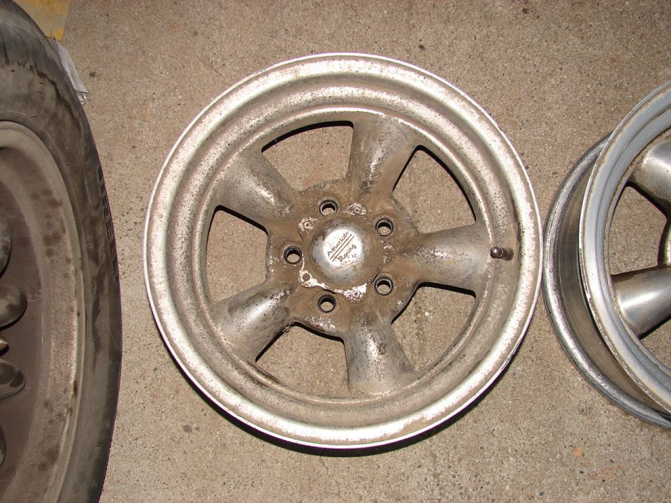Silver American Racing wheel with five spokes and a center cap