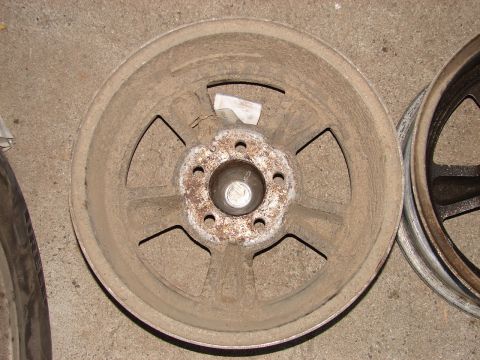 1973 Ford Ranchero - A single, dusty five-spoke aluminum wheel is shown, with another wheel partially visible to the right.