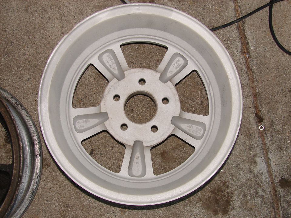 Close-up of a silver five-spoke aftermarket wheel with some text cast into the spokes