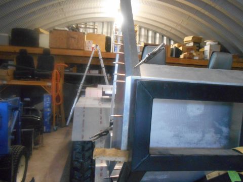 1992 Ford Bronco - Workshop scene with a partially constructed metal object and various stored items in the background.