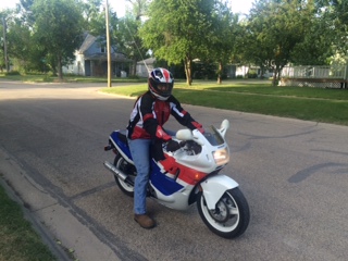 1989 Honda CBR600F - Rider on a 1989 Honda CBR600F motorcycle on a suburban street.