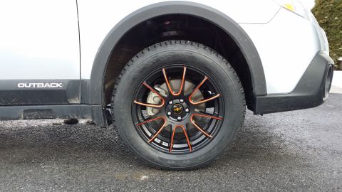 2014 Subaru Outback - Close-up of a silver Subaru Outback's front passenger side wheel and fender area.