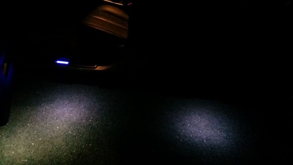 Interior door panel with blue puddle light illuminating the ground
