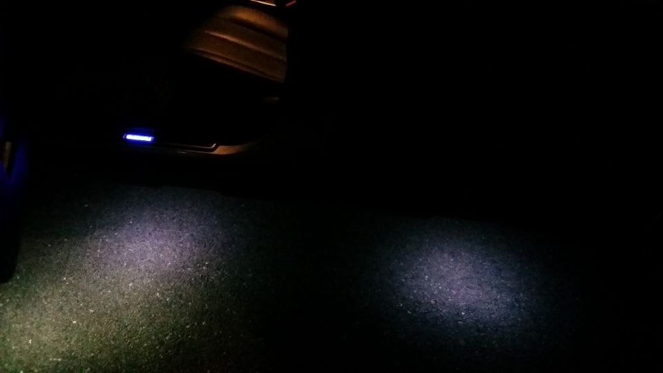 Interior car door light shining on asphalt
