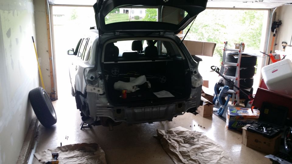 Rear of a 2014 Subaru Outback undergoing repairs in a garage