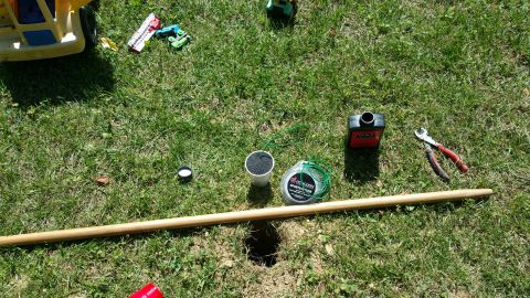 2007 Subaru Impreza - Supplies for yard maintenance are gathered on the lawn, including a pole, trimmer line, oil, and cutters, next to a freshly dug hole.